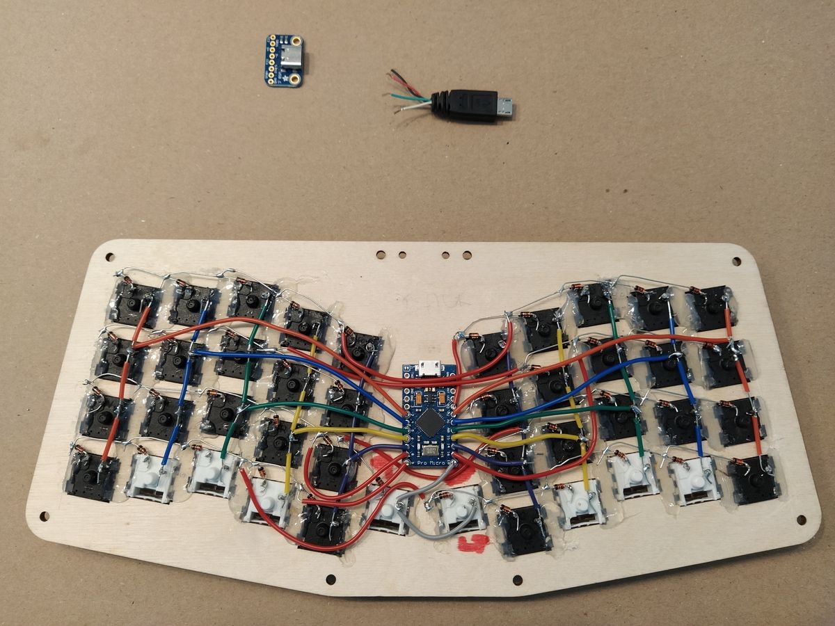 Completed keyboard wiring with red and black diodes on row pins, multi-colored column wires, and Pro Micro microcontroller soldered with wires