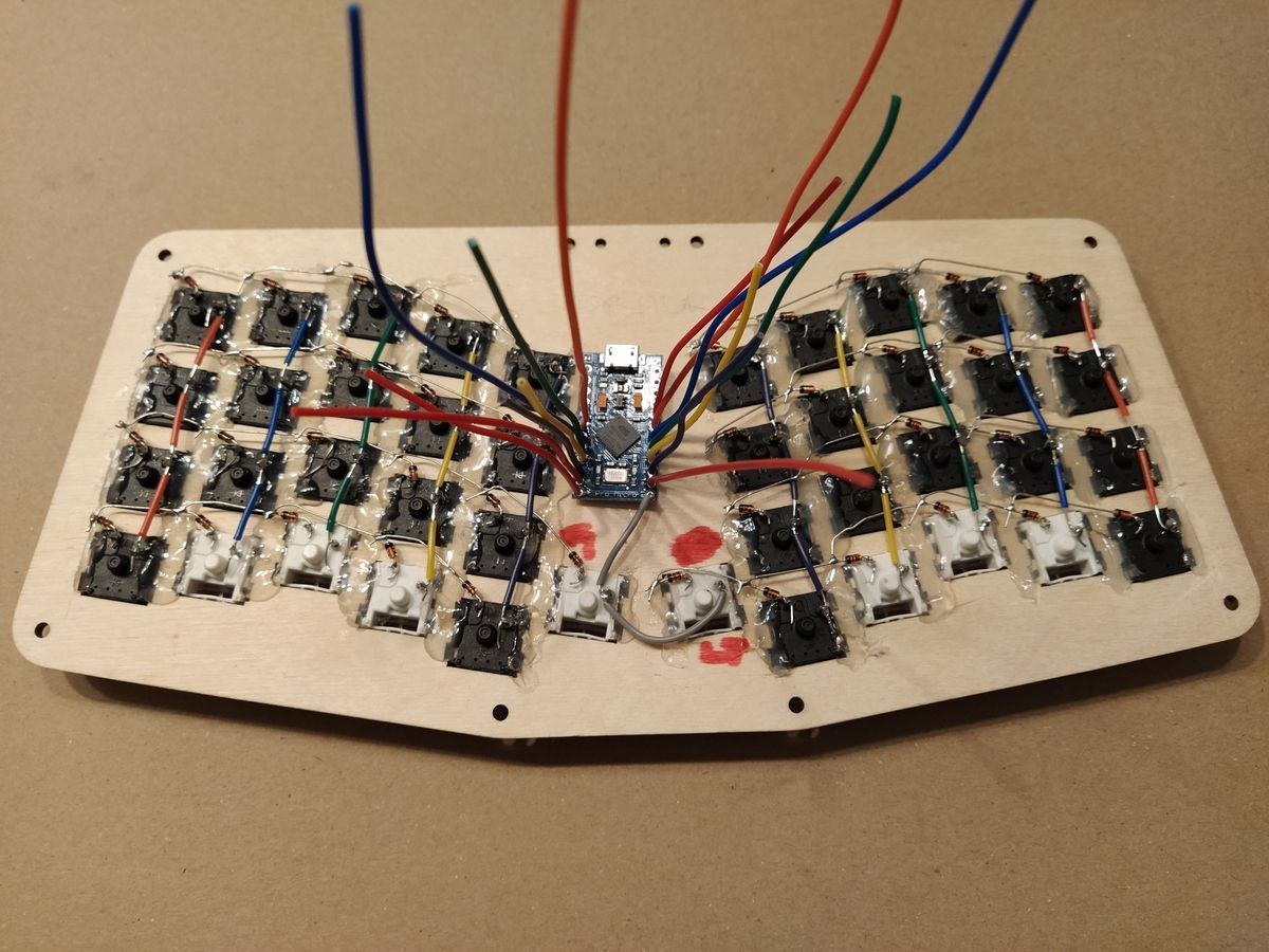 Microcontroller dry-fitted in between the two clusters of the keyboard.