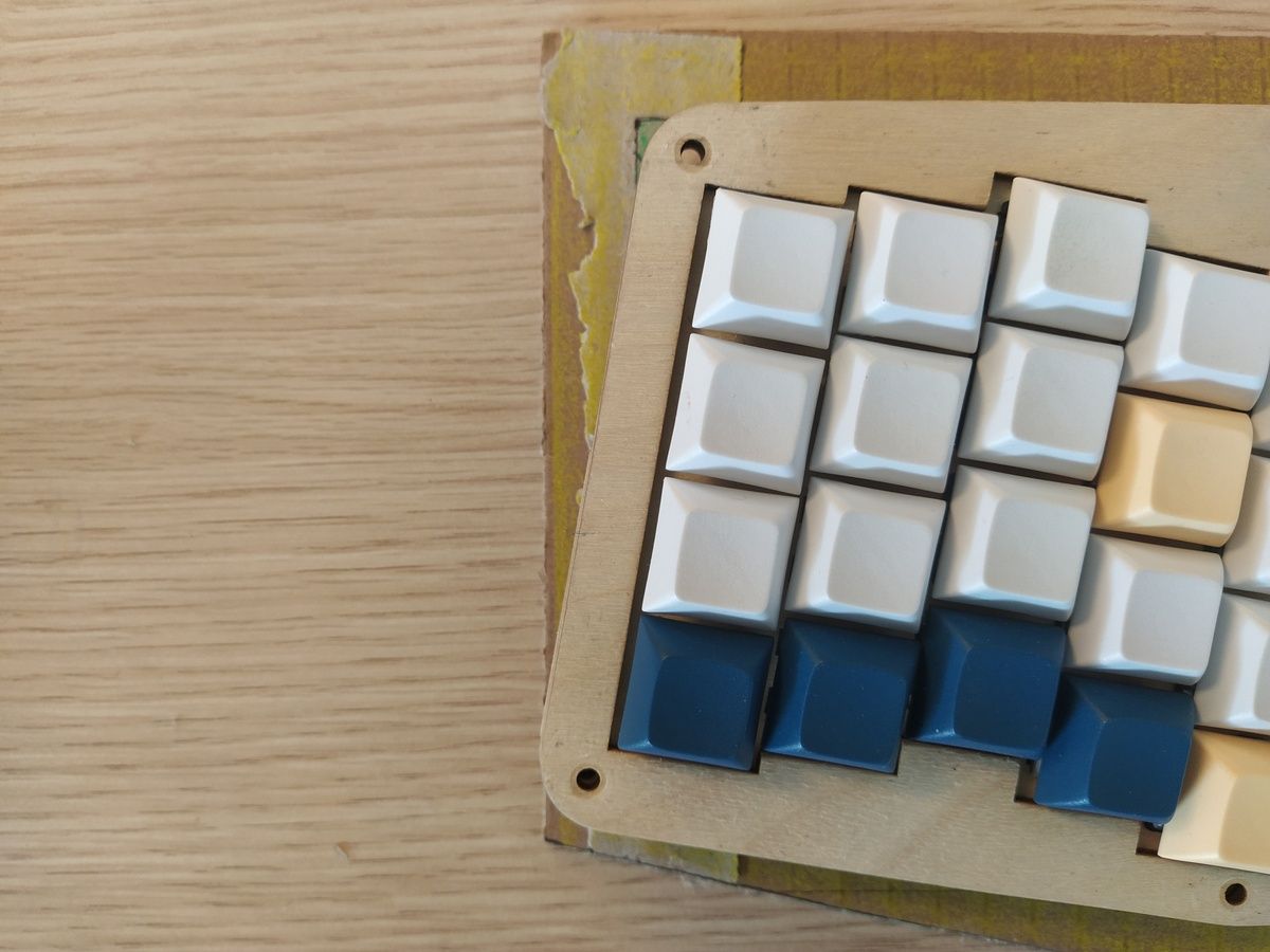 Closeup of the top-left corner where the keyboard meets the cardboard edge.